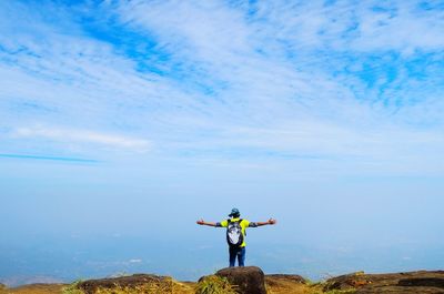 Full length of man standing against blue sky