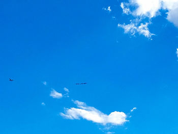 Low angle view of airplane flying against blue sky