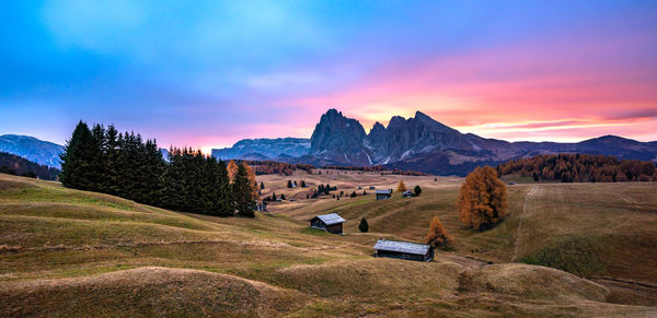 Scenic view of field and mountains against sky during sunset