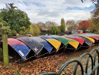 Multi colored umbrellas on field against sky