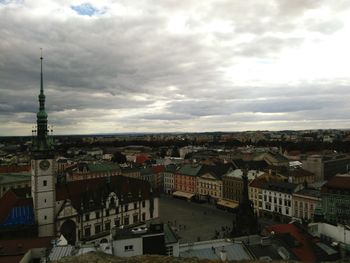 Buildings in town against cloudy sky