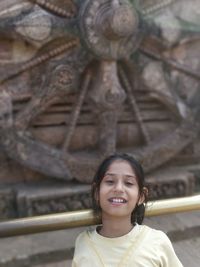 Portrait of smiling girl against carving