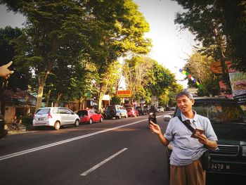 Portrait of smiling girl standing against tree