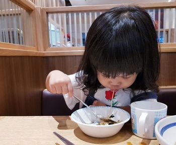 Portrait of cute girl sitting on table