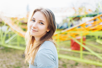 Happy young gen z woman with trendy blue hair in amusement park. summer, sunlight