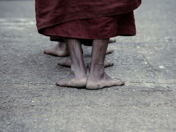 Low section of monks standing in row on road