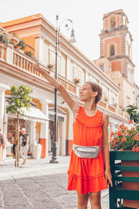 Portrait of young woman standing in city