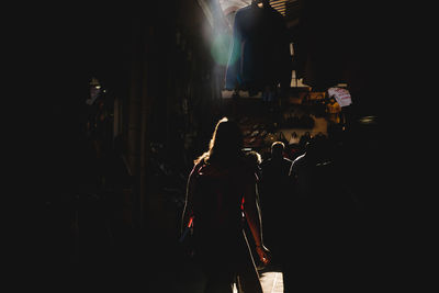 People walking on illuminated street in city