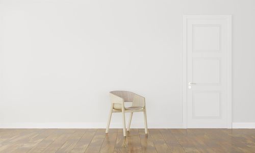 Empty chair against white wall at home