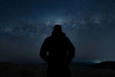 Silhouette man standing against sky at night