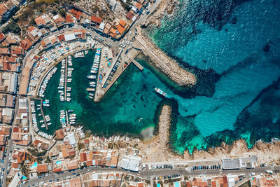 Aerial view of of boat moored in bay by cityscape