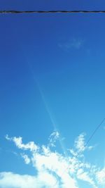 Low angle view of vapor trail in blue sky