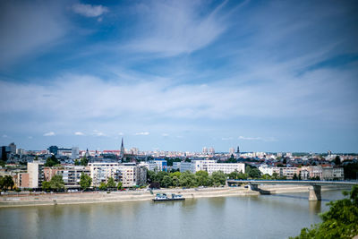 Buildings in city against cloudy sky