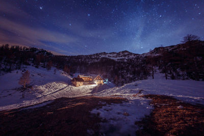 Scenic view of snowcapped mountains against sky at night