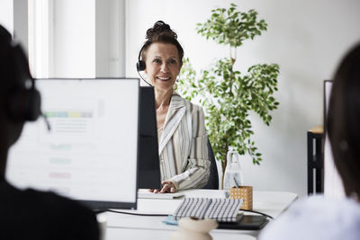 Smiling mature woman working in call center