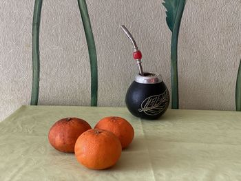 Close-up of fruits on table against wall at home