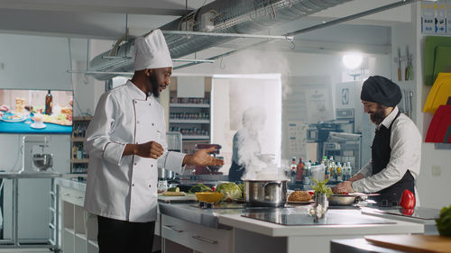 Chef preparing food in kitchen at restaurant