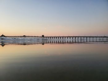Pier over sea against sky during sunset