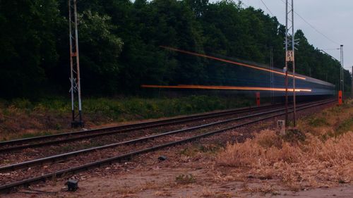 Railroad tracks by trees against sky