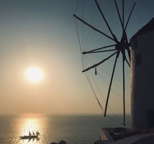Silhouette sailboat in sea against sky during sunset