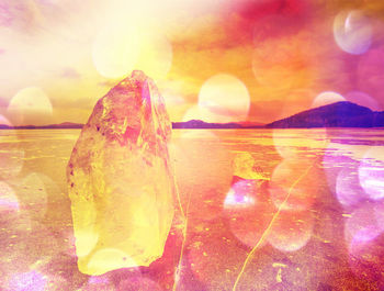 Digital composite image of sun shining through rocks during sunset