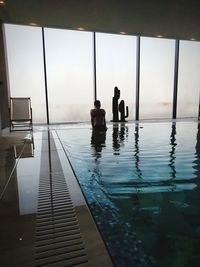 People standing by swimming pool