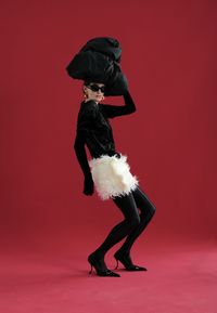 Low section of man standing against yellow background