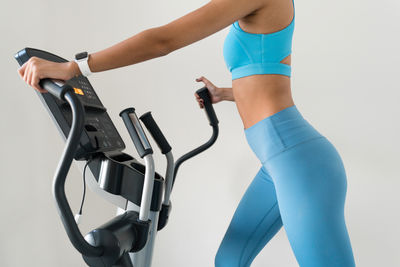 Young woman training at the gym using eliptical crosstrainer