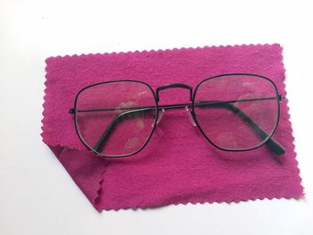 High angle view of eyeglasses on paper against white background