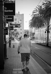 Rear view of man walking on road