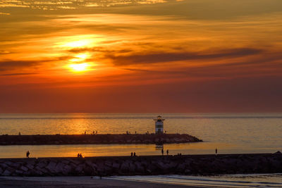 Scenic view of sea against sky during sunset. entrance of the fishing harbour in scheveningen.