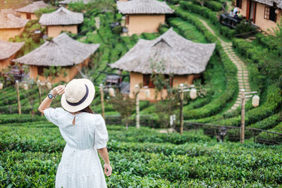 Rear view of woman standing by plants