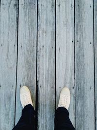 Low section of man standing on boardwalk