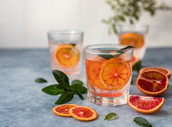 Gin and tonic alcohol drink with blood sicilian oranges and ice. cold refreshing cocktail.