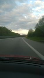 Country road against cloudy sky