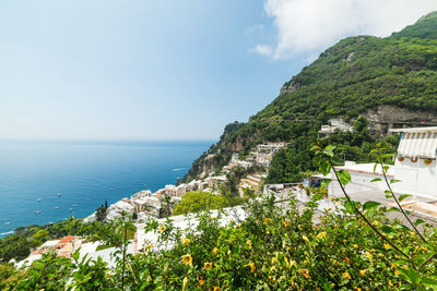 Scenic view of sea by buildings against sky