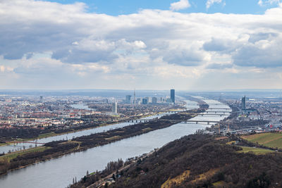 High angle view of buildings by river against sky