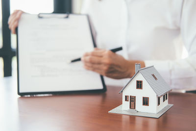 Person holding umbrella on table in house
