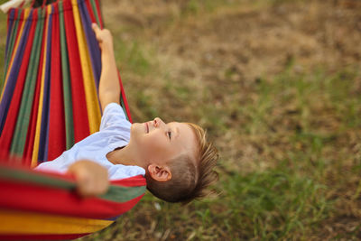 Smiling boy lying on hammock