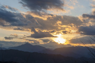 Low angle view of silhouette mountains against dramatic sky