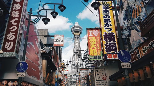 Low angle view of sign on street against buildings in city