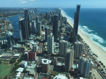 High angle view of modern buildings by sea against sky