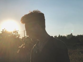 Portrait of young man standing against sky during sunset