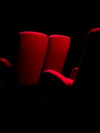 Close-up of empty chairs against black background