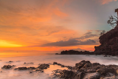 Scenic view of sea against orange sky