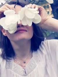 Close-up portrait of woman with white flowers