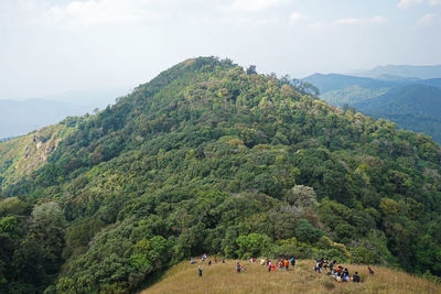Backpackers trekking among natural landscape of green mountain rage
