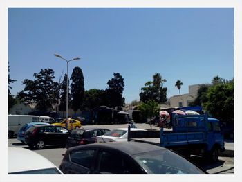 Cars parked on road against clear sky