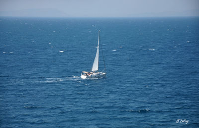 Sailboat sailing in sea against sky