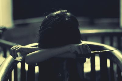 Girl sitting on chair with scissors